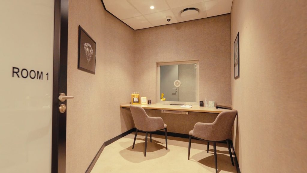 Private valuation room at The Gold Avenue, Illovo Point, Sandton, with two chairs, a service hatch and a CCTV dome
