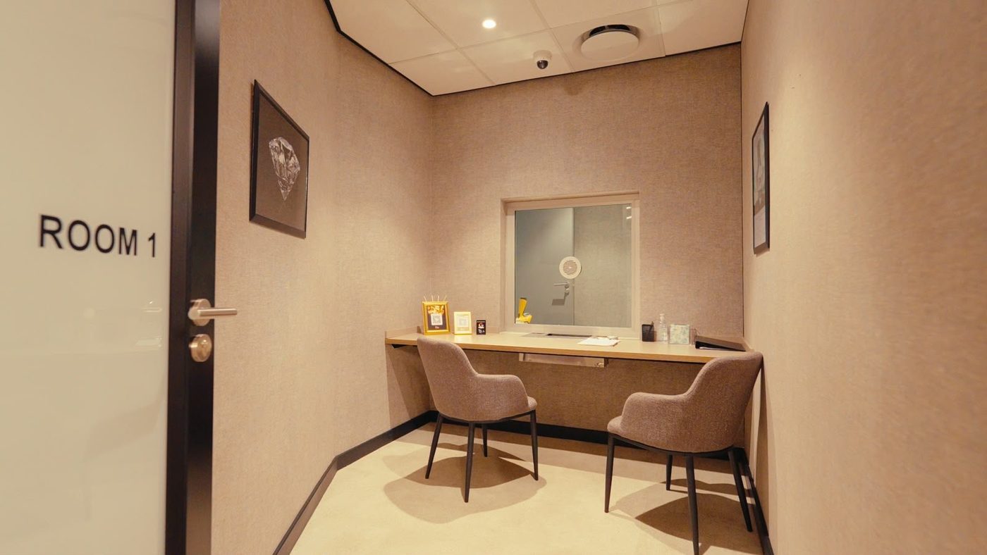 Private valuation room at The Gold Avenue, Illovo Point, Sandton, with two chairs, a service hatch and a CCTV dome